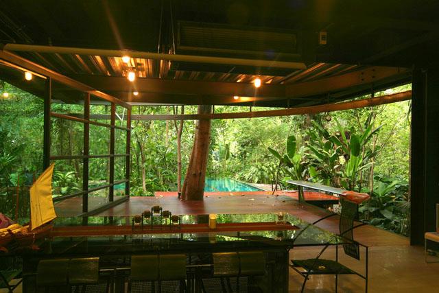 By rolling away the glass panel, the dining area opens to the terrace and the swimming pool