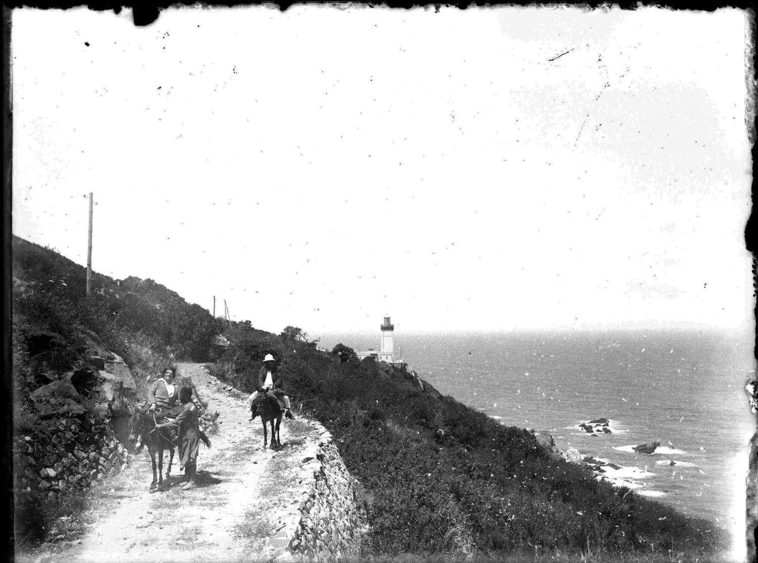 View from the east of a couple on mules traveling on the lighthouse road