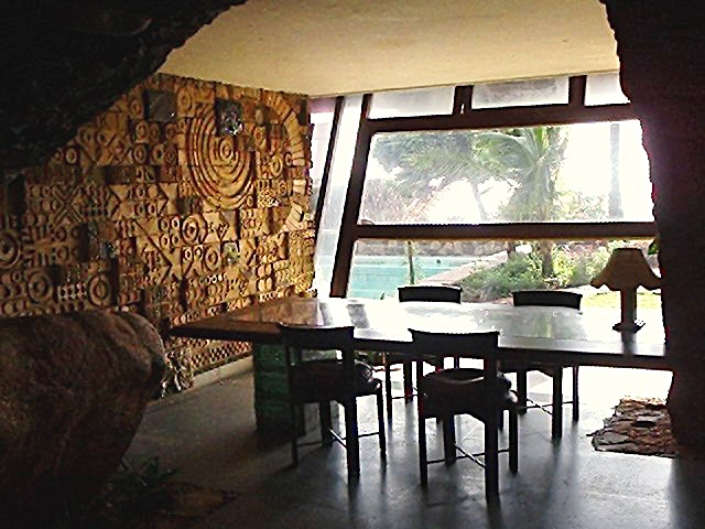 Moon Dust Residence - View of the dining area with a mural wall at left; beyond the glazed slanted wall is the beach