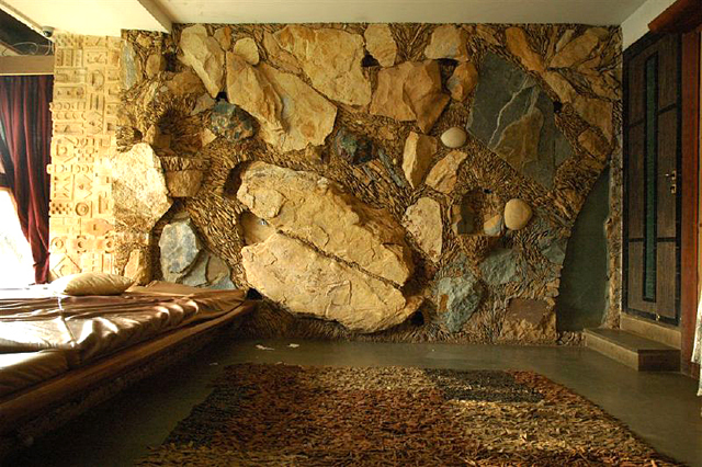 Moon Dust Residence - Interior view looking at a stone wall made in situ using stone chips, large dressed stones, and boulders