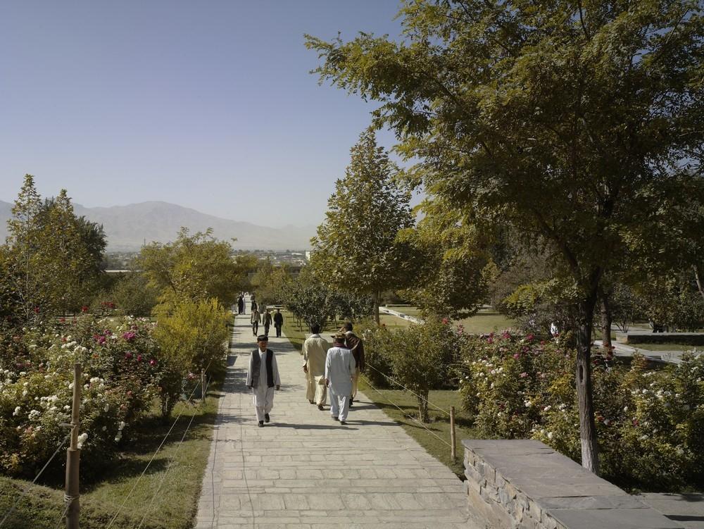 Visitors walking along the main east-west axis of Baghe Babur which connects the entrance of the garden at the bottom of the site to Babur’s grave in the upper terraces