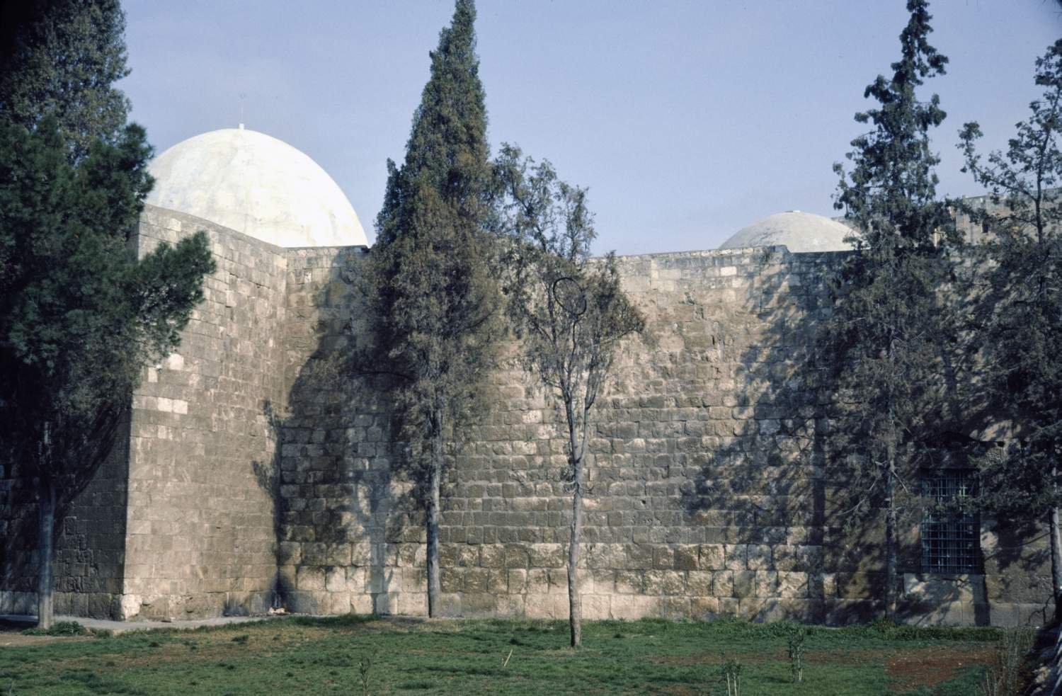Exterior view of complex from south, showing domes over prayer hall (at left) and tomb chamber (at right).