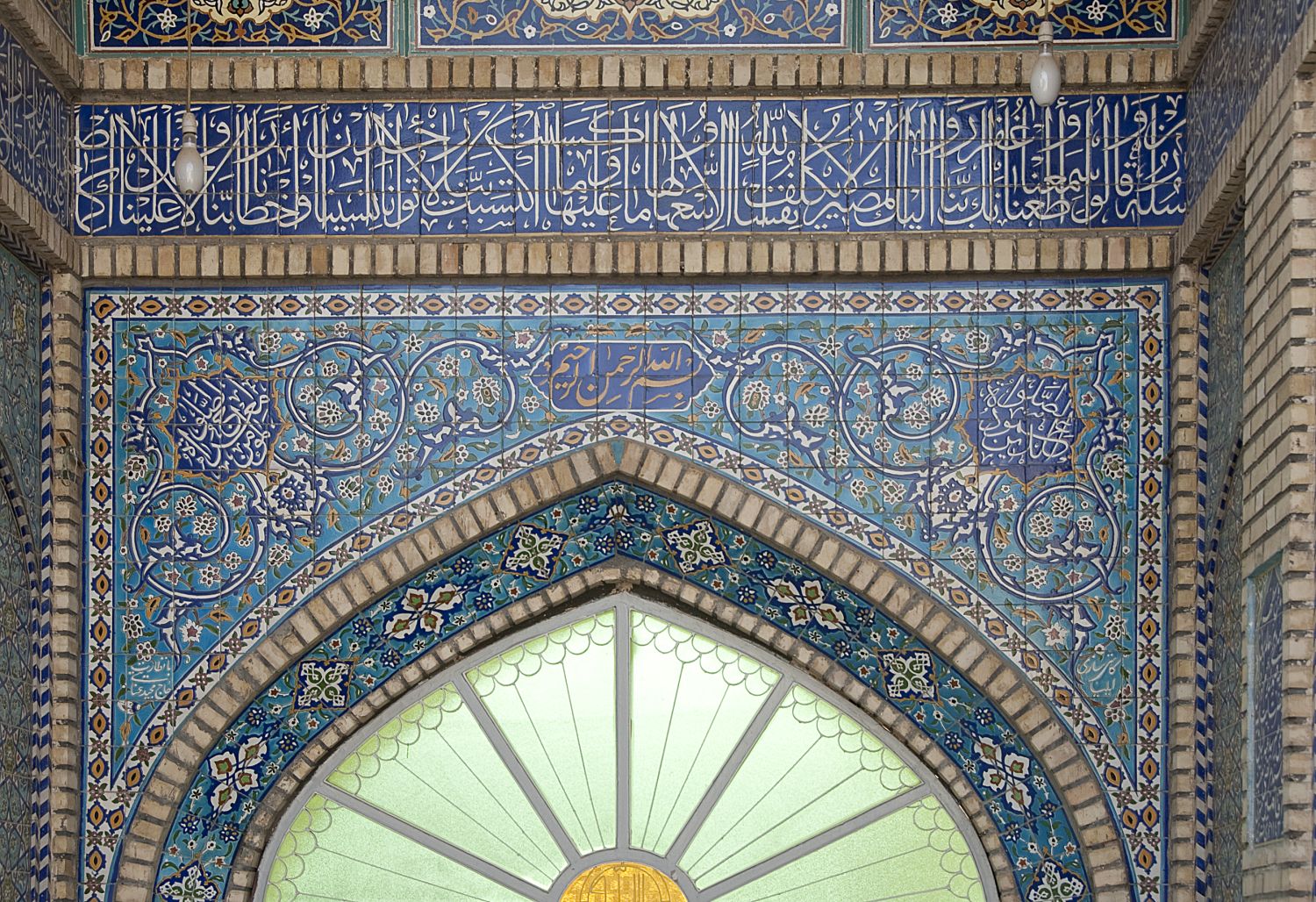 Entrance portal: view of lunette over doorway and tile decoration and inscription.&nbsp;