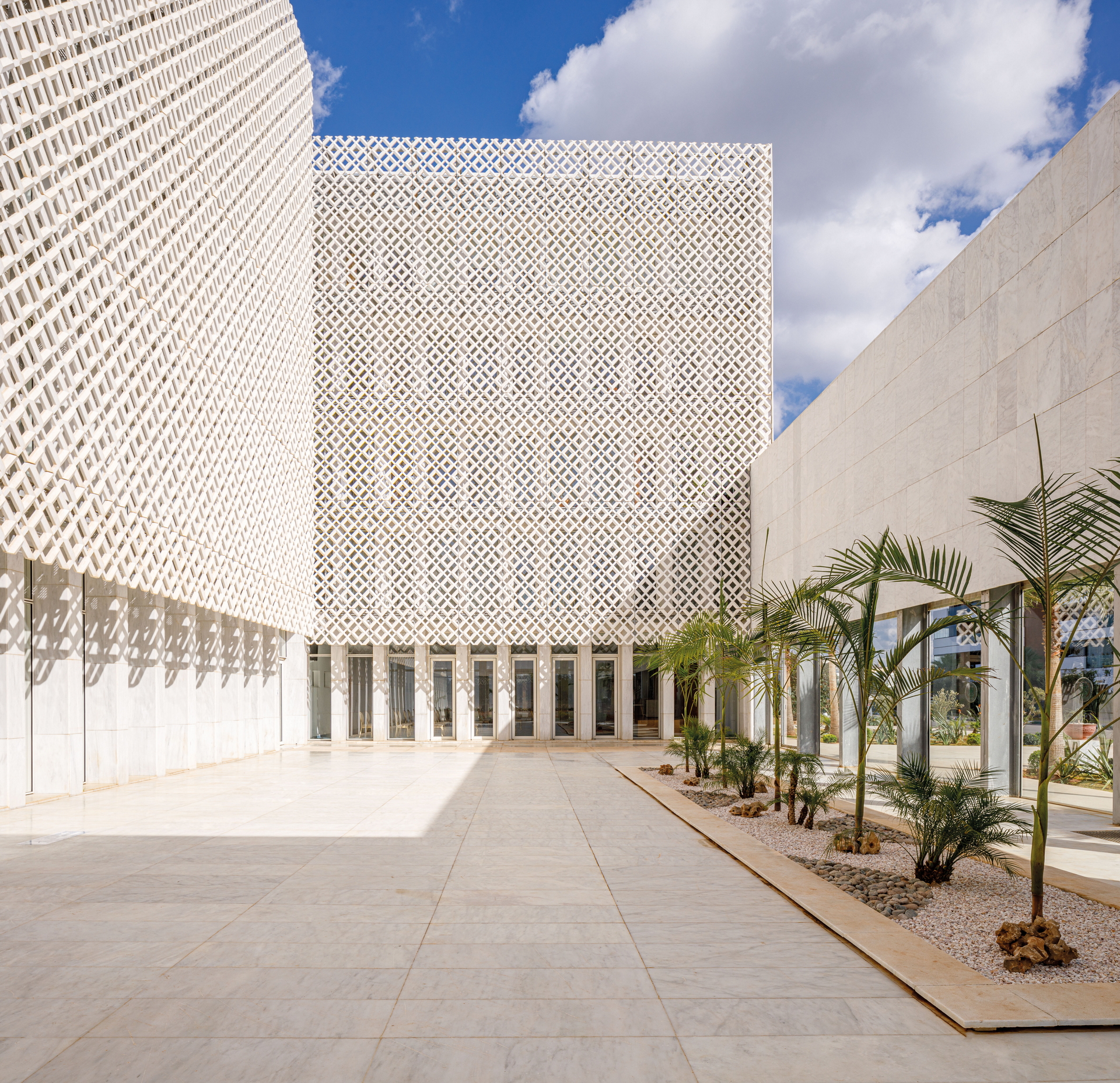 <p>Patio. &nbsp;All of the exteriors of the upper floors feature perforated marble screens that serve as mashrabiyya to temper the harsh sunlight, and the design of the building is conceived as a contemporary interpretation of traditional medinas.</p>