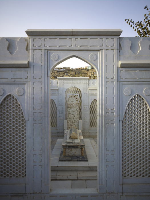 Carved jali screens flank the opening on the marble enclosure around Babur's grave
