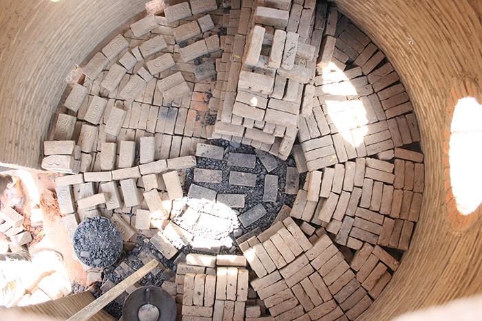 Product bricks stacked within kiln allowing air movement for combustion  