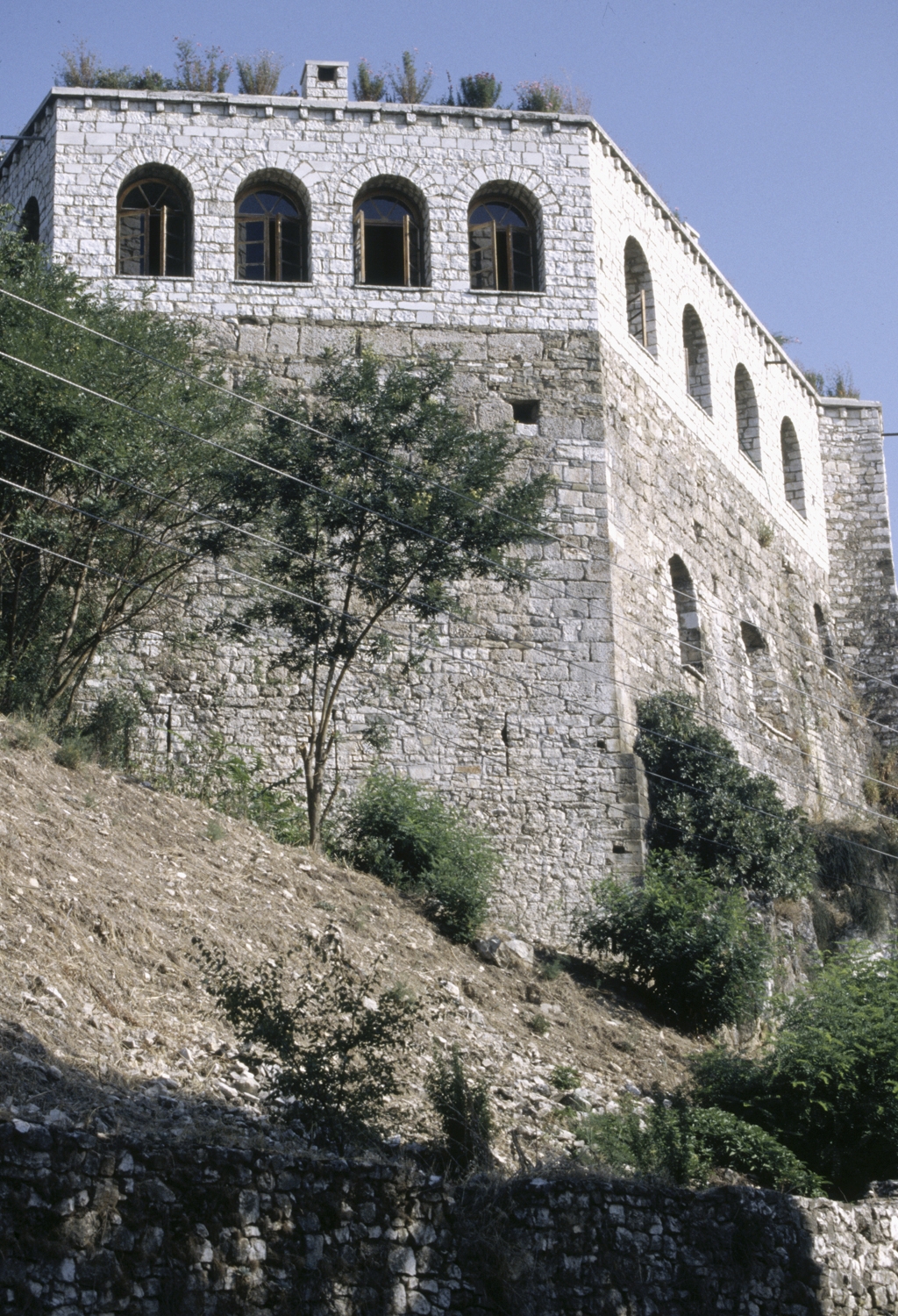 View from below of fortress on hilltop, with restored upper story