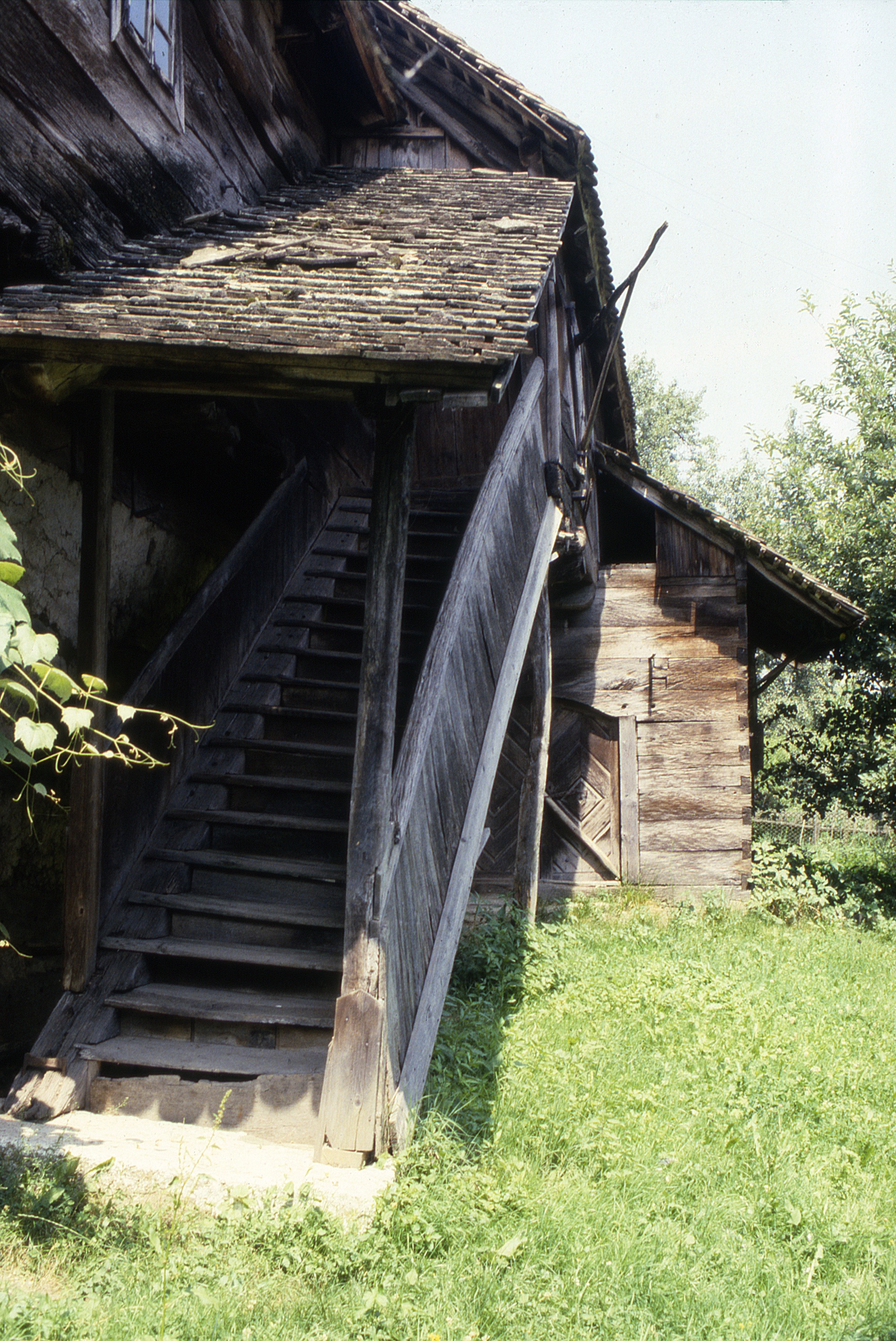 <p>Covered wooden stairways lead to the upper level living quarters of the čardak dwellings of the Turopolje and Pokuplje regions, a distinguishing feature of this vernacular building type. The two timber stair stringers were notched to accept the wooden treads and a rail set on the outer stringer to give additional shelter during inclement weather.</p><p>The house was uninhabited and deteriorating in 1988, but planned for eventual restoration as a folk museum.</p><p>(photo 1988)</p>