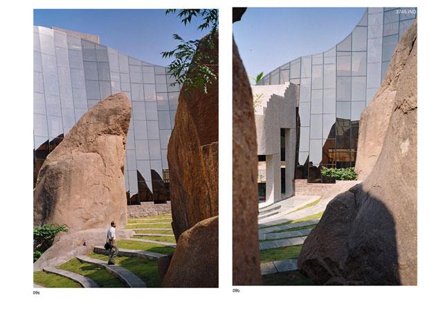View of the landscaped court, rocks and building as one enters through the pedestrian entry. - Part of arrival lounge seen through the rocks