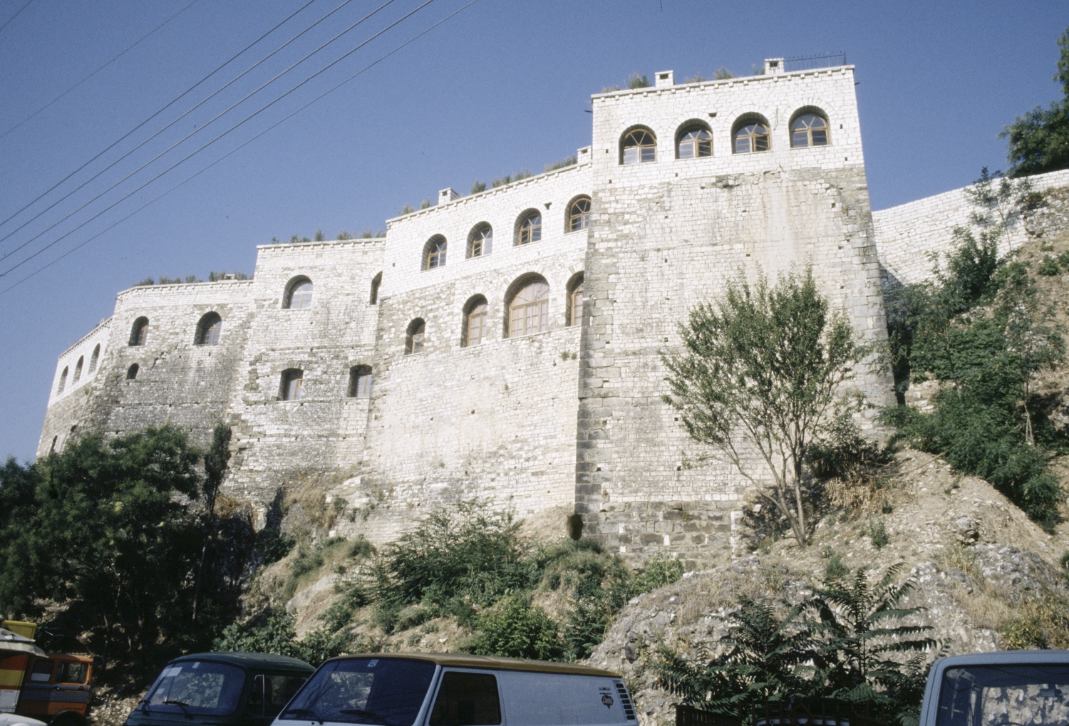 View from below of fortress on hilltop, with restored upper story