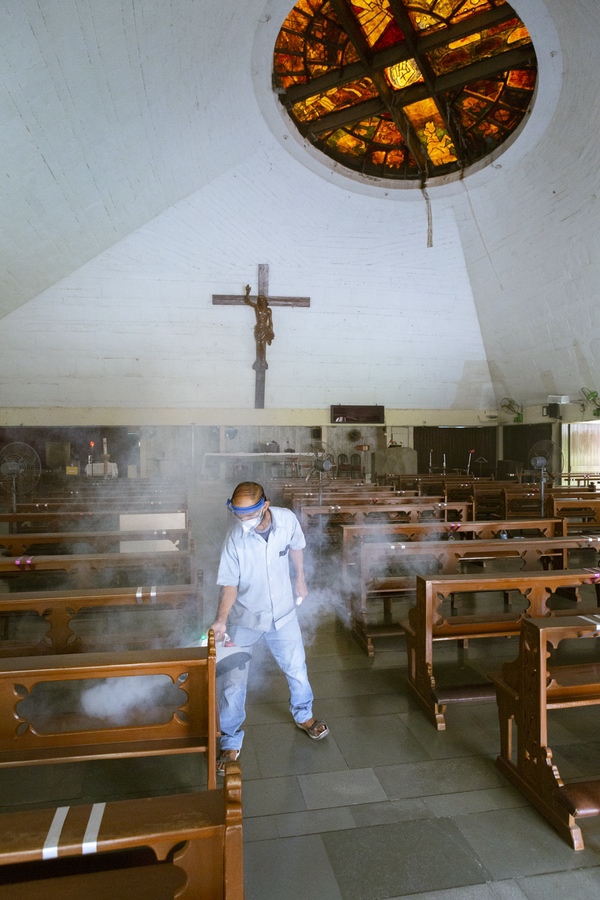<p>A church employee sanitising the seating in nave</p>