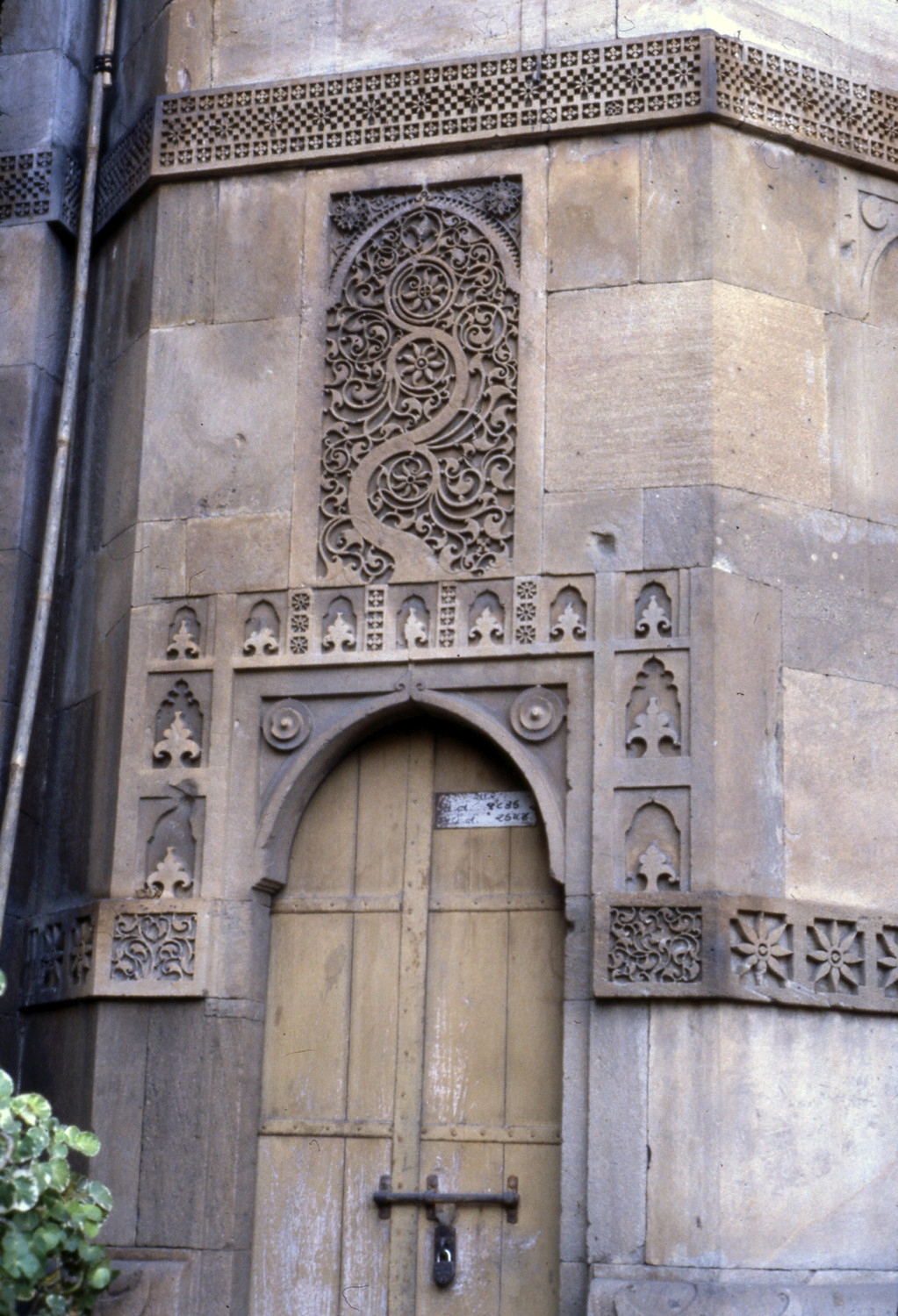 Exterior, detail of northeast corner tower, entrance door and ornament
