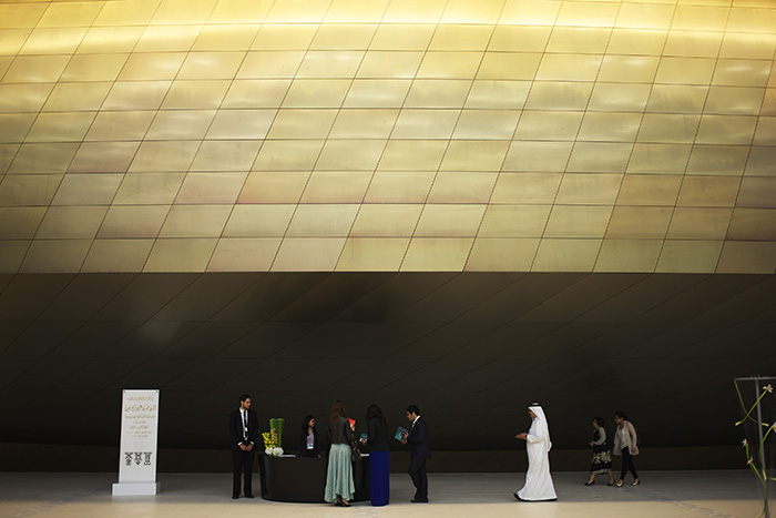 The main auditorium volume covered with stainless steel with golden reflection  