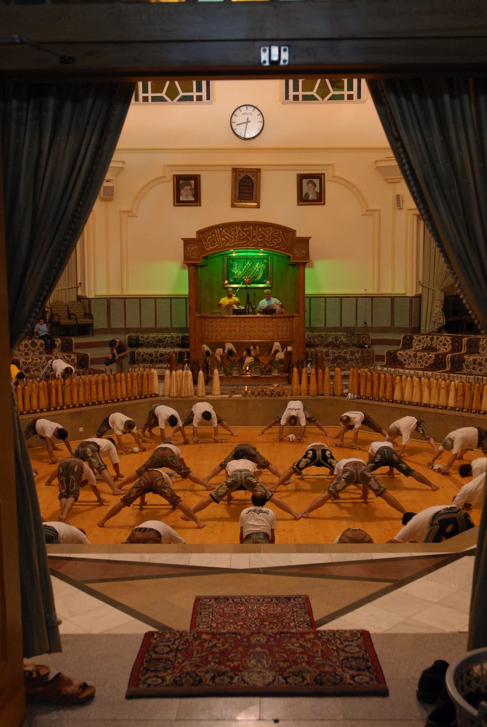 Interior of the Zurkhaneh Astan-i Qods, Mashhad, 2006. Athletes performing the shinā exercise (synchronized pushups)