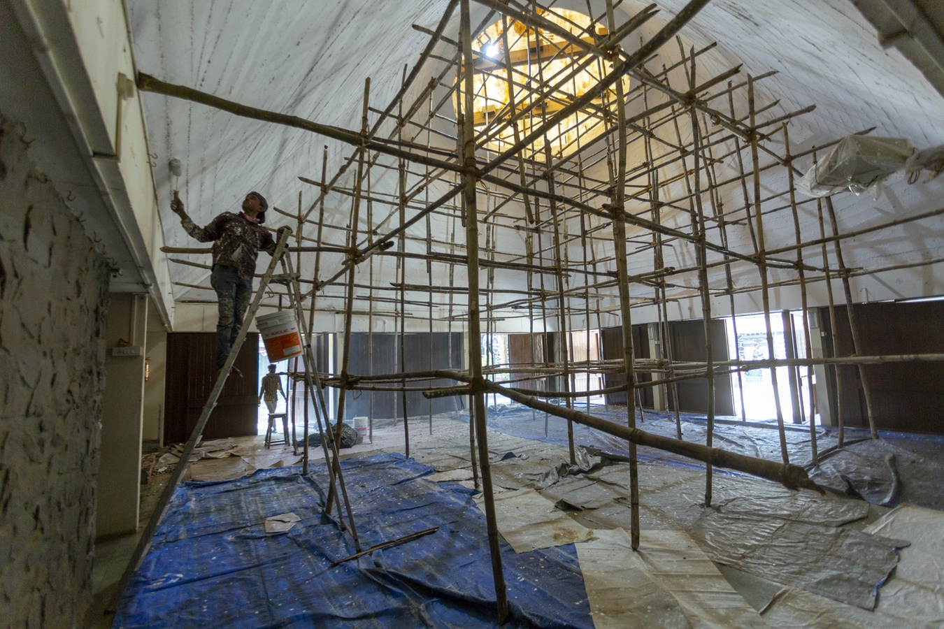 <p>Workers painting the exposed concrete of the oratory hall in white</p>