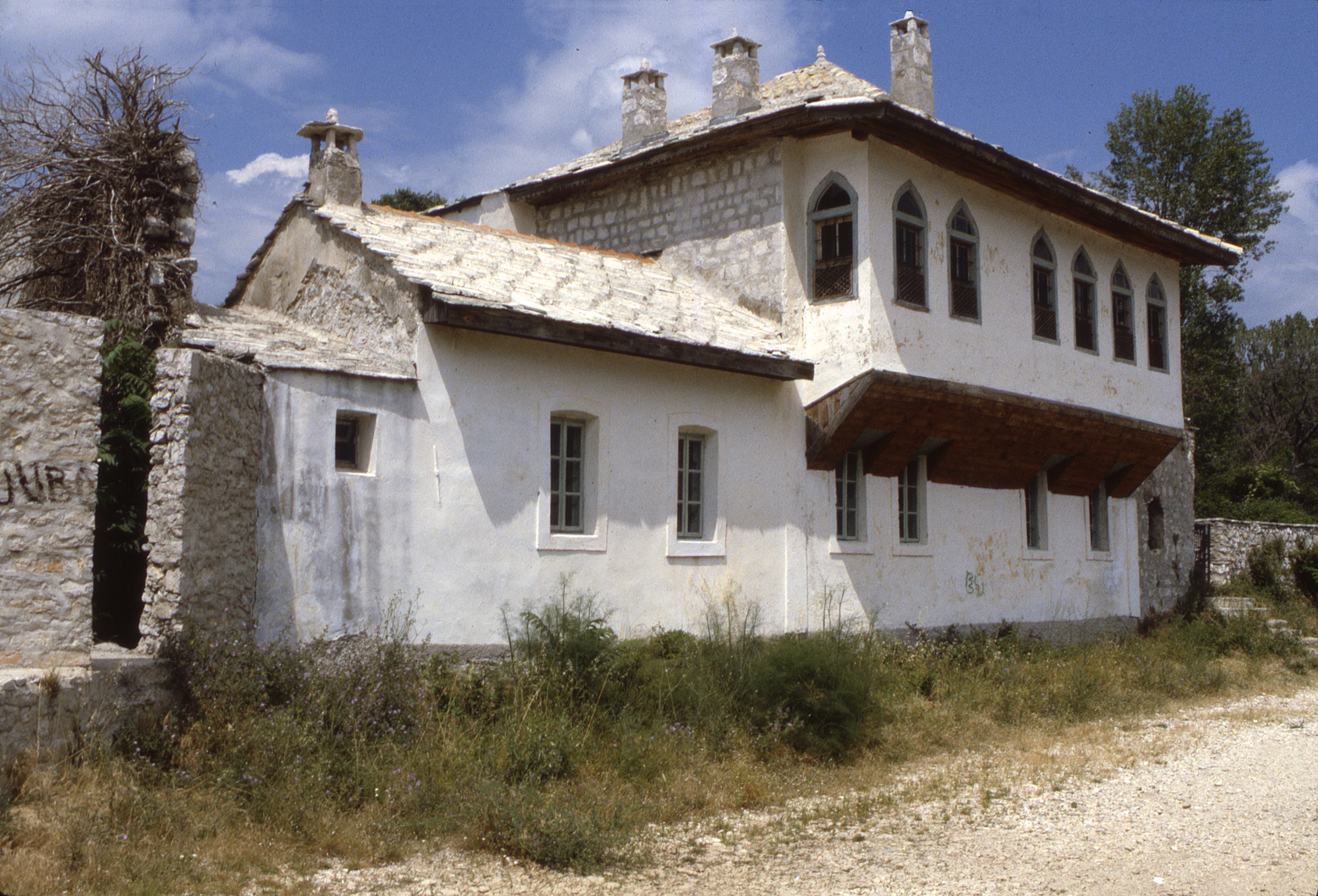 <p>The Resulbegović family lived in the ground floor spaces during the winter and the upper level during the milder months. The lower walls are stone covered with a plaster and the upper walls of wooden braced framing filled with lighter soft brick and covered with plaster. The exposed stone extension in the distance was a storeroom that provided a terrace above. The south projecting facade (doksat) of the dwelling faced the Trebišnjica river. The house forms the southern edge of the family (haremluk) courtyard that also contained a konak for guests.</p>
