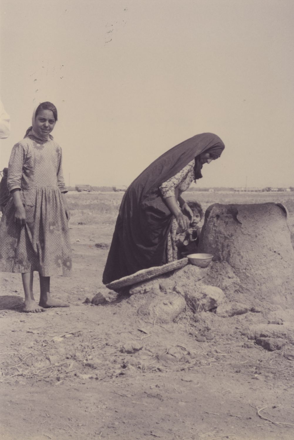 Woman baking bread in a tanuur (clay oven) near Karbala, Iraq.