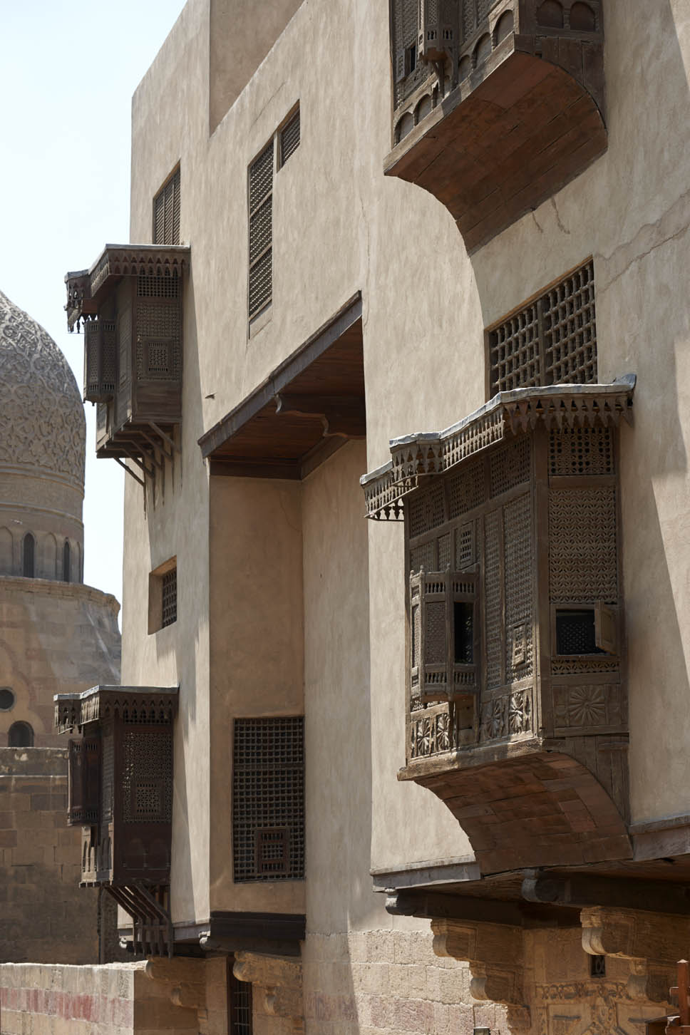 Oblique view along an exterior facade, with mashrabiya