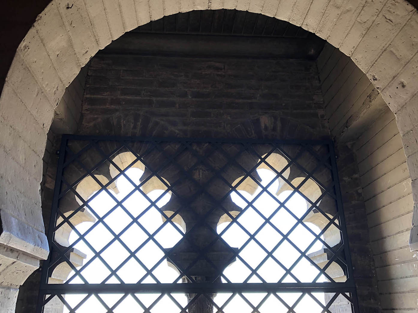 Detail view of cinque foil window arches through the top of a horseshoe arch in La Giralda.
