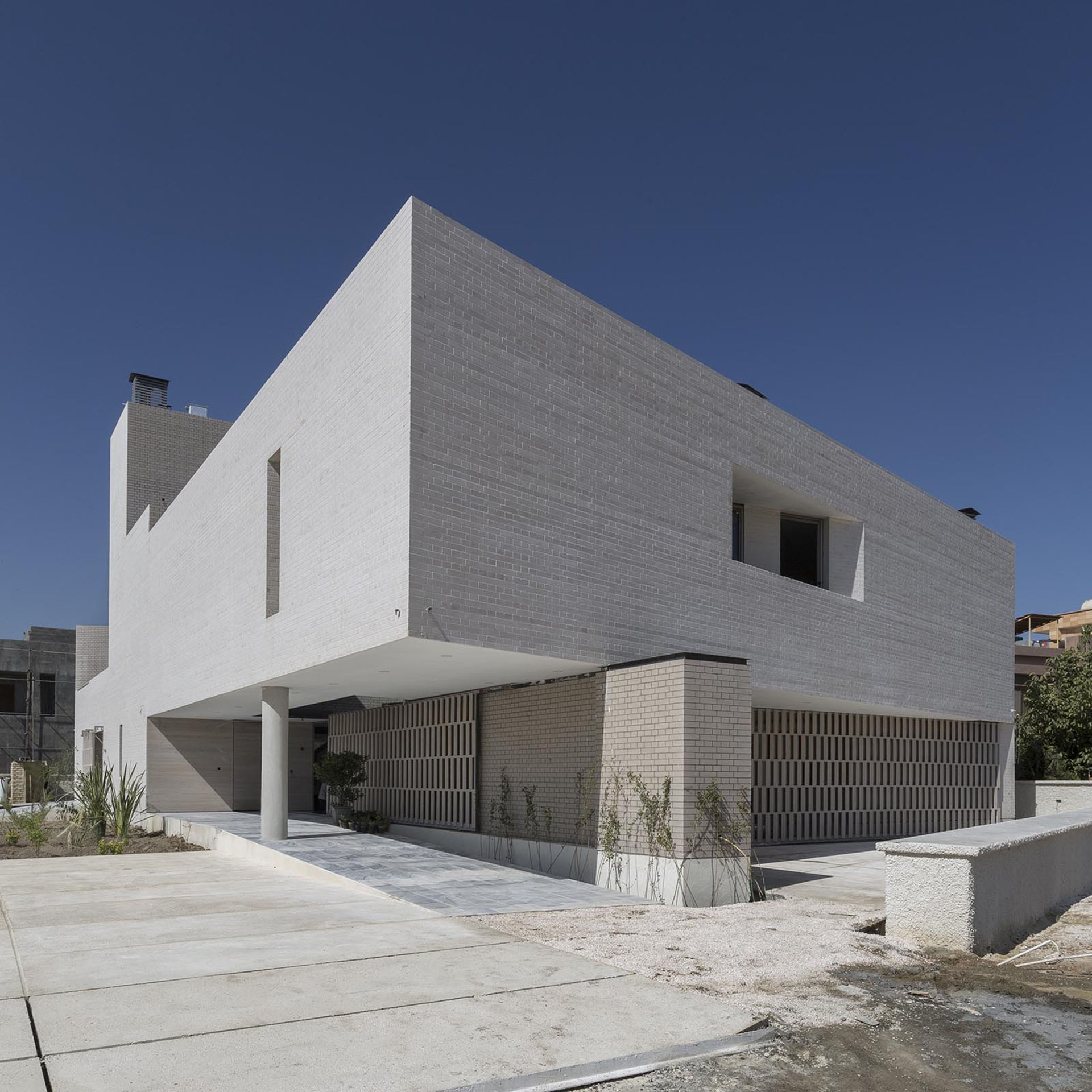<p>While ensuring privacy from the exterior, the concrete and brick secondary residence blurs the distinction between inside and outside through the use of courtyards.</p>