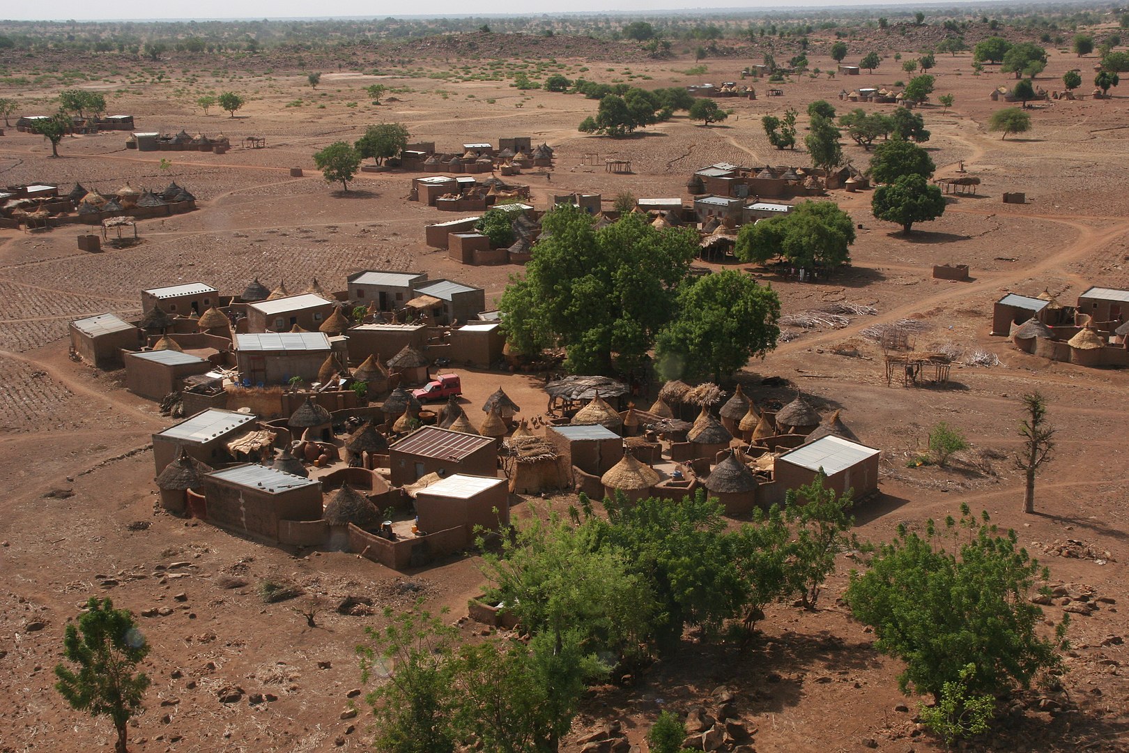 <p>General view of Gando Village showing clusters of vernacular, earthen housing with either conical and flat roofs</p>