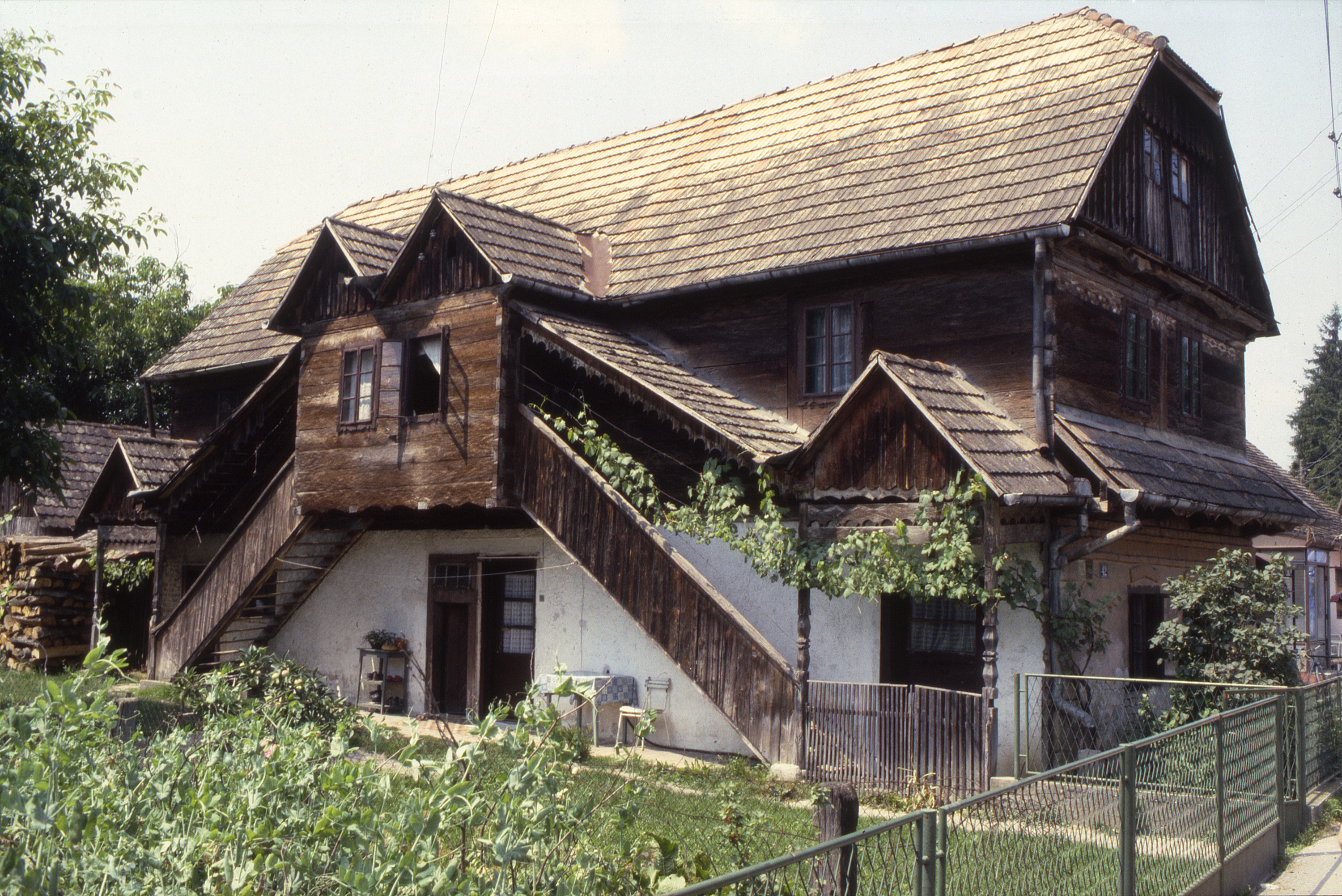 Judith Bing - <p>Lekenik is a town along the main road from Zagreb to Sisak, and this house is typical of the čardak dwellings along this route, yet distinguished by its doubled stair which provides access to both street and yard. Small roof gables articulate these two entry ways at top and bottom. Plaster coats the ground level for added weatherproofing, and a pent roof protects this surface on the street elevation</p>