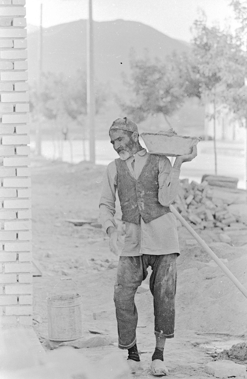 Dennis Briskin - Bricklayer carrying mortar in Arak, Iran.