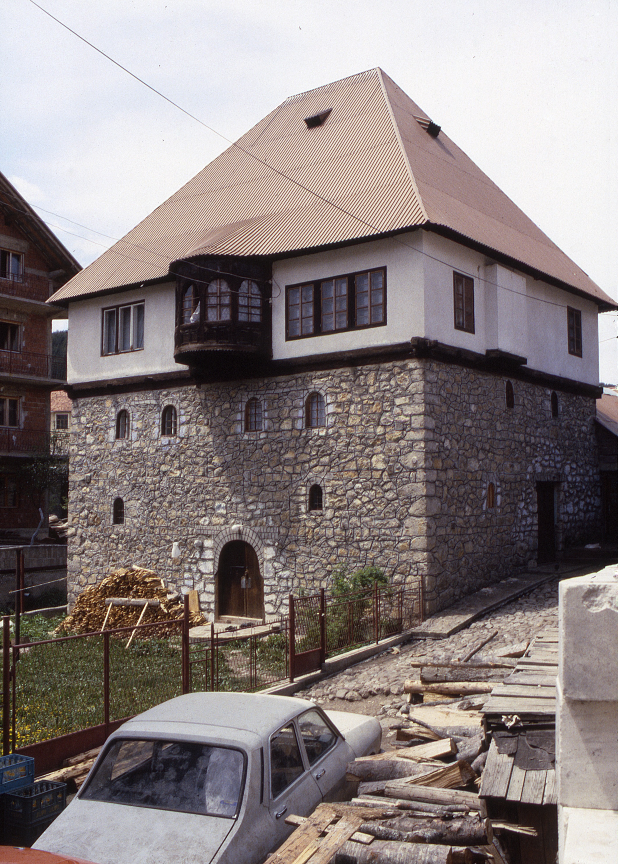 <p>This large kula with ground entrances on two levels is under renovation. The lowest level walls are constructed of stone with three major coursed strips of stone and arch-shaped stonework over window openings. The top level floor, walls and roof framing are timber. These walls were constructed using infill of wattle and daub covered with plaster. The oriel window appears to have a raised floor as in čardak spaces. The steep roof is covered with corrugated panels. The small opens in the roof are typical of those found in traditional dwellings and used to ventilate the building. </p>
