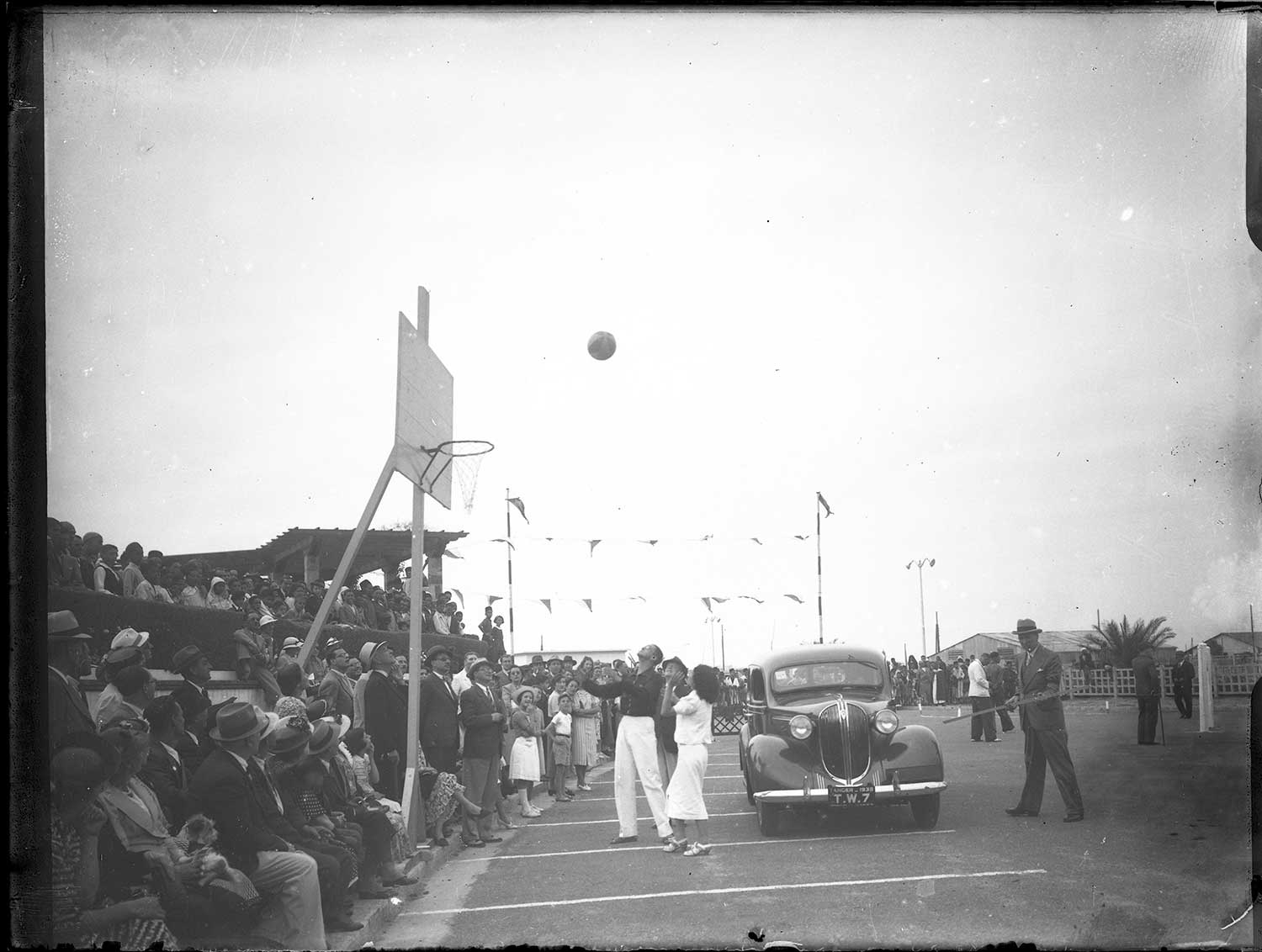 View of spectators behind a basketball net in a parking lot
