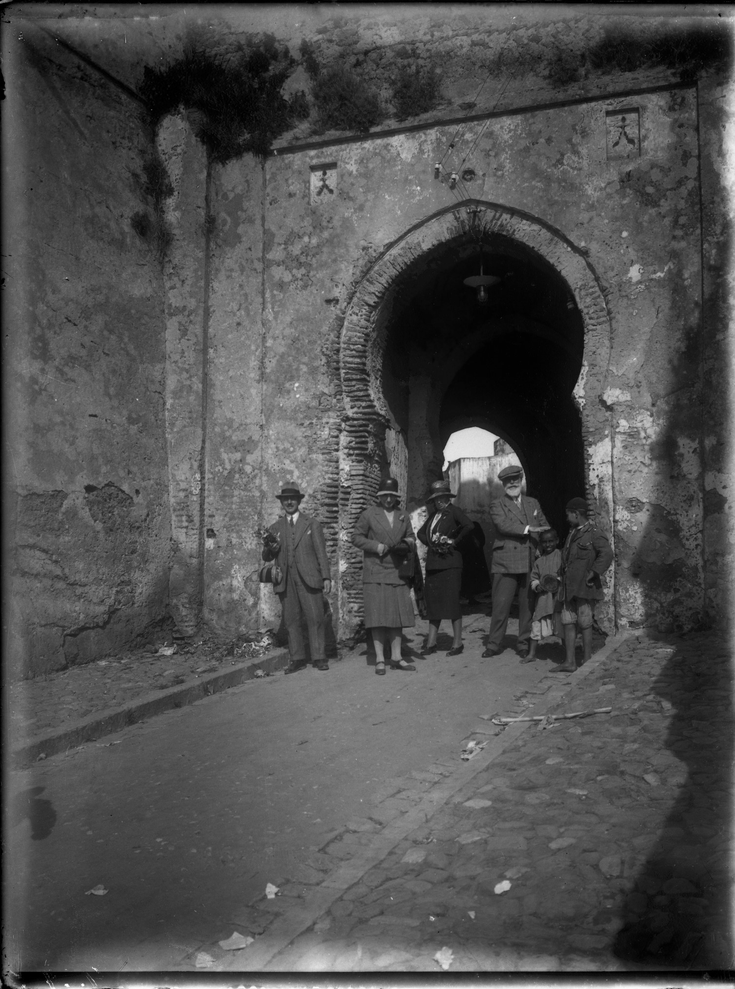 Group, in  European dress, standing under horseshoe archway