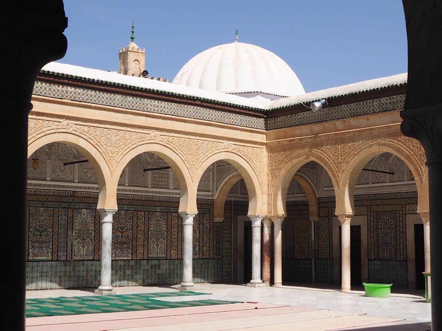 View to the northeast corner of the zawiya courtyard showing faience tile and stucco decorations with vegetal and geometric motifs. Also visible are the neo-Corinthian columns in two types of marble.<div>&nbsp;</div>