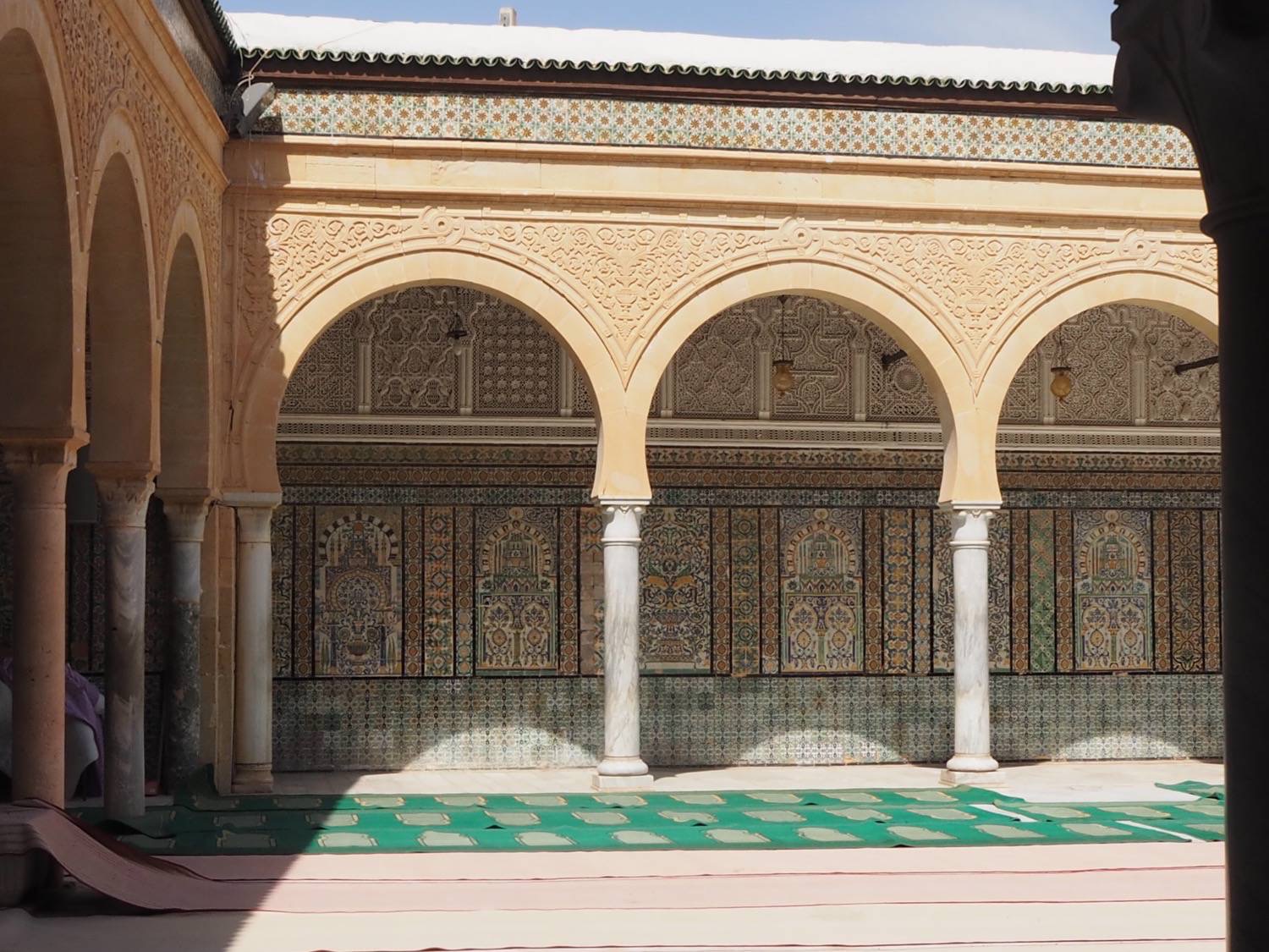 Detail view of stucco and tile decorations in a corner of the zawiya courtyard