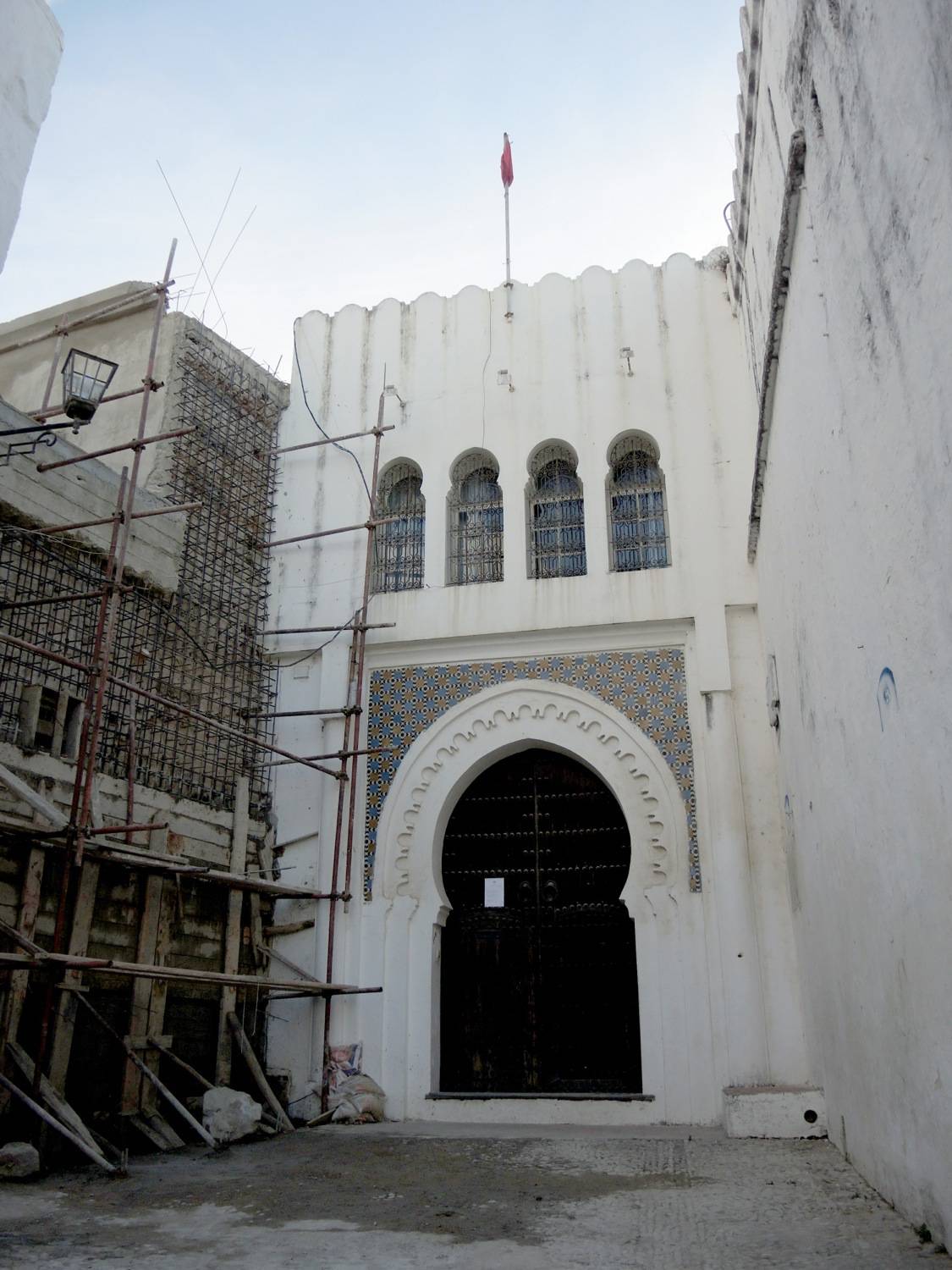 View of the entrance to Dar al-Makhzen and restoration work on the facade of Jami' al-Qsaba to the left