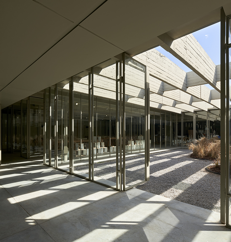 <p>Defined by a series of lightweight steel and glass panels registering the ceiling's rhythmic structural grid, the new flexible partition allows for all functions to seamlessly connect to each other and to the central courtyard beyond.</p>