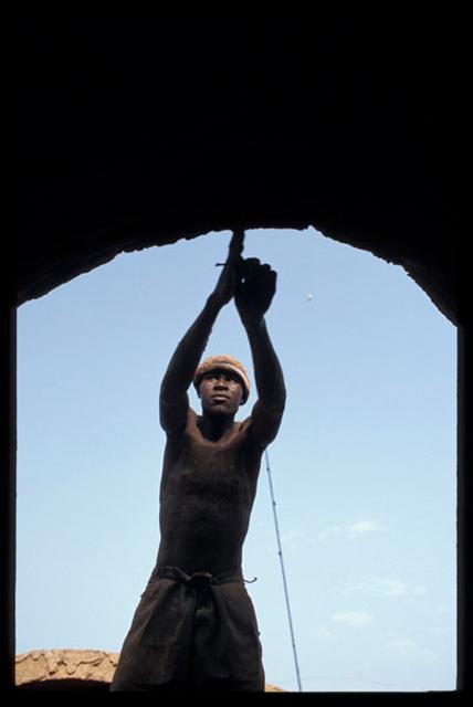 Worker using a compass to position a brick. They are positioned as a semi circle around the vault axis