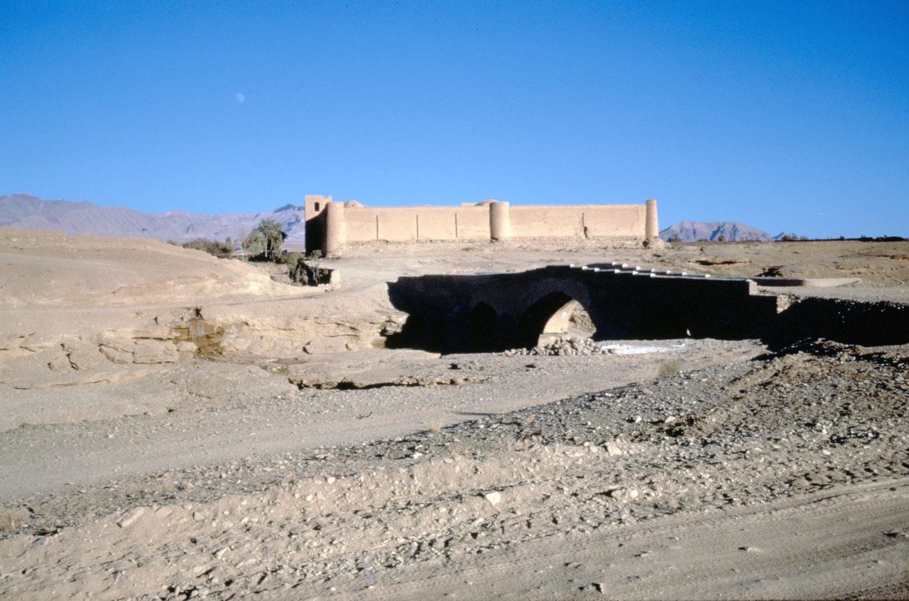 General view showing the bridge in foreground and the caravanserai in background