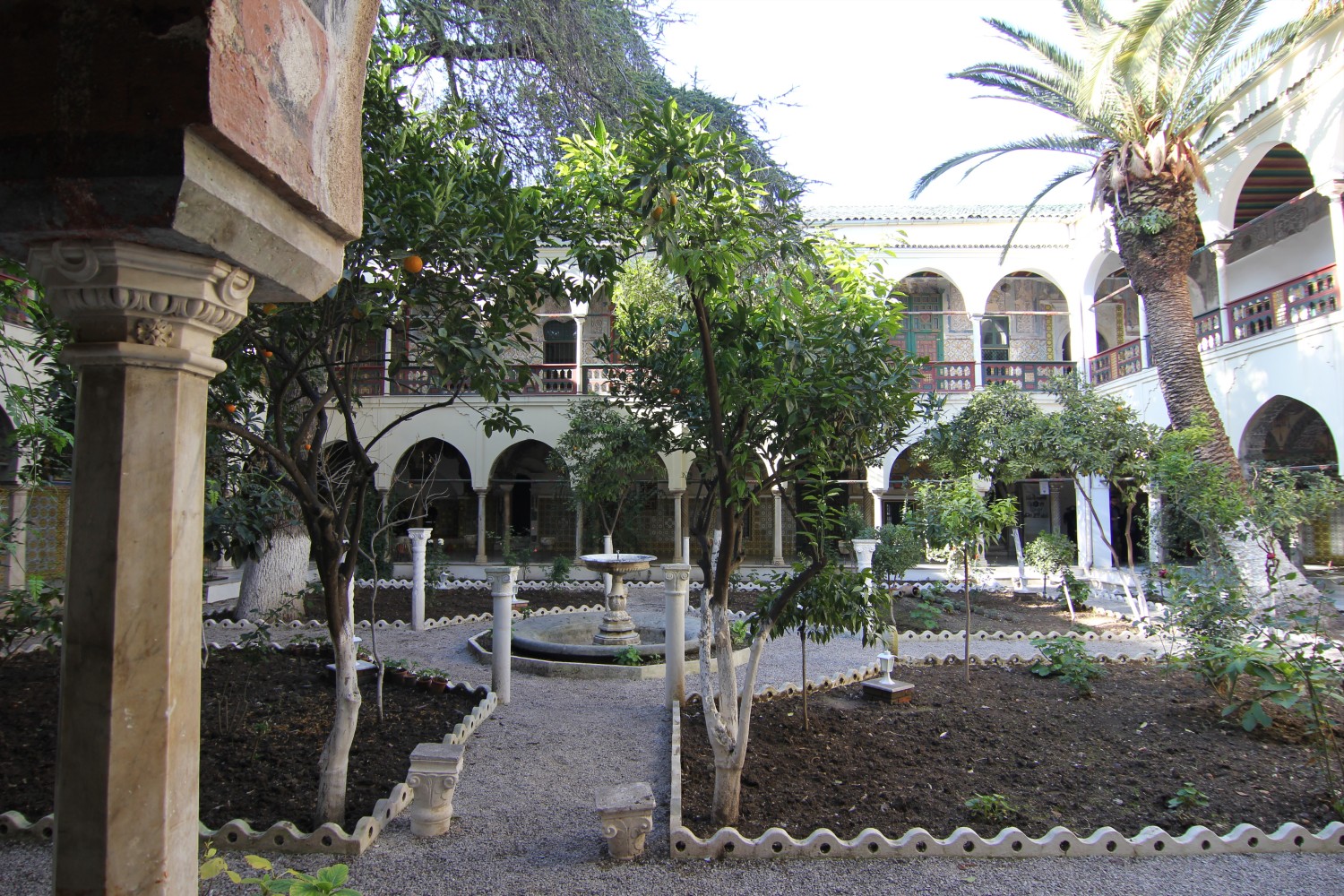 Orange trees garden, axial view showing central fountain and west galleries, on the left is visible an octagonal capital with crescent shapes as decorations