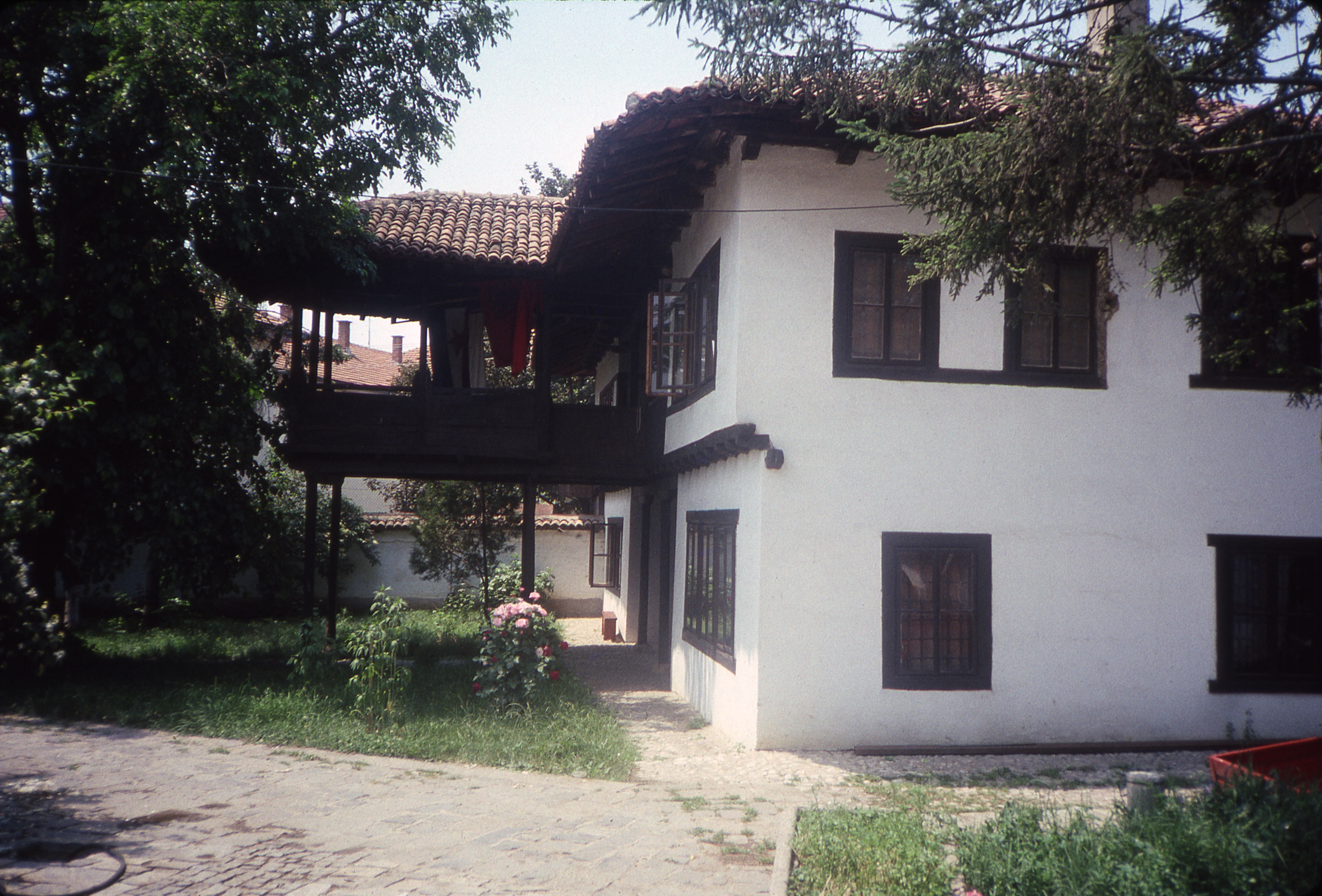 <p>This house that was owned by the Kocadiši family was constructed during the late Ottoman period and is set within a walled garden. The symmetrically composed dwelling has a central hall that opens to the large projecting čardak, which has built-in seating around its perimeter. It is currently the home of the Kosovo Institute for the Perservation of Cultural Monuments. The survey drawings of this dwelling show that there had previously been an exterior wooden stair on the far side of the čardak (and along the dwelling wall) to allow easy access to the upper level.</p>