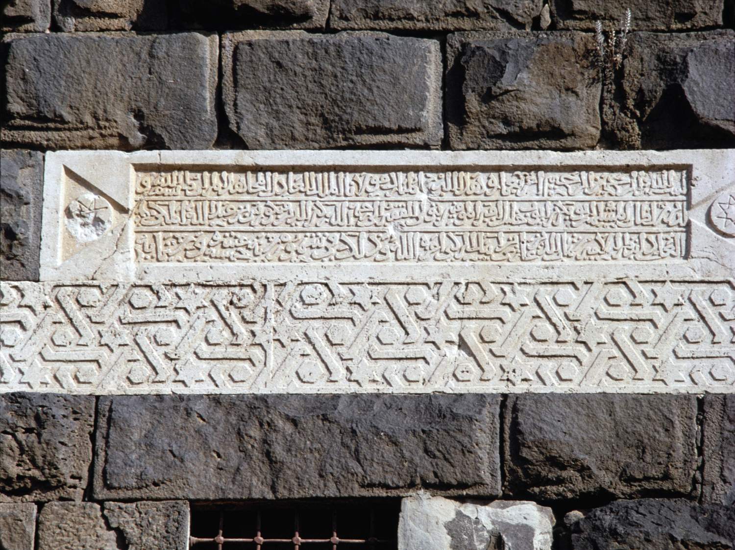 View of inscription in a tabula ansata and a band of geometric ornament below.