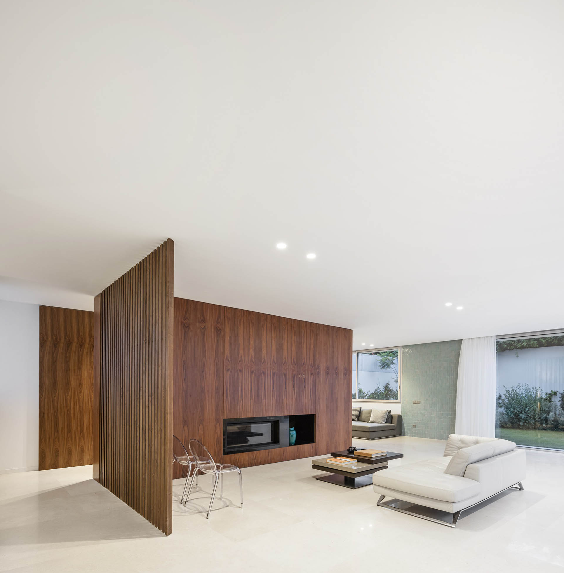 <p>&nbsp;The main living area features an extended wood-clad fireplace wall that screens the service areas behind it.&nbsp;&nbsp;</p>