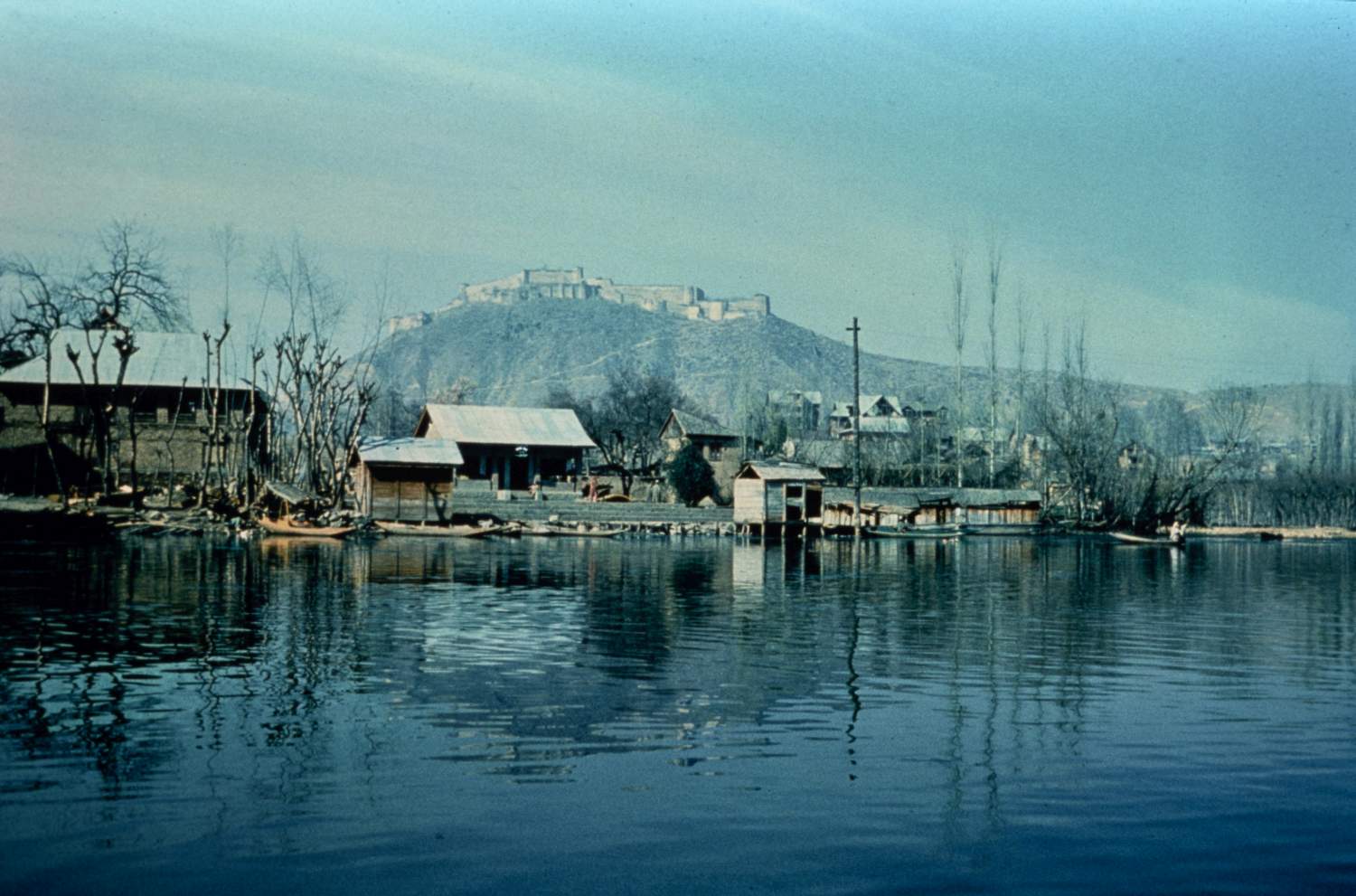 Structures along shore of Dal Lake. Hari Parabat is visible in background.