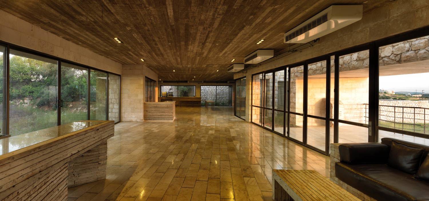 Interior view from the entrance lobby to the restaurant showing the exposed concrete ceiling and the use of Aljouni lime stone for flooring and interior cladding