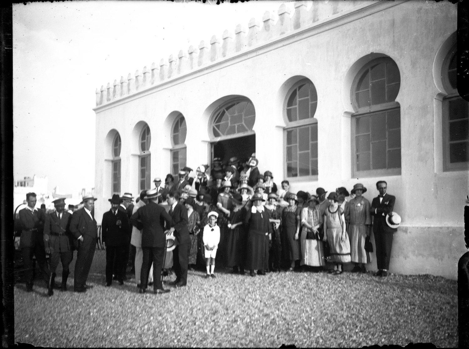 Large group of people, in European dress, standing outside a building