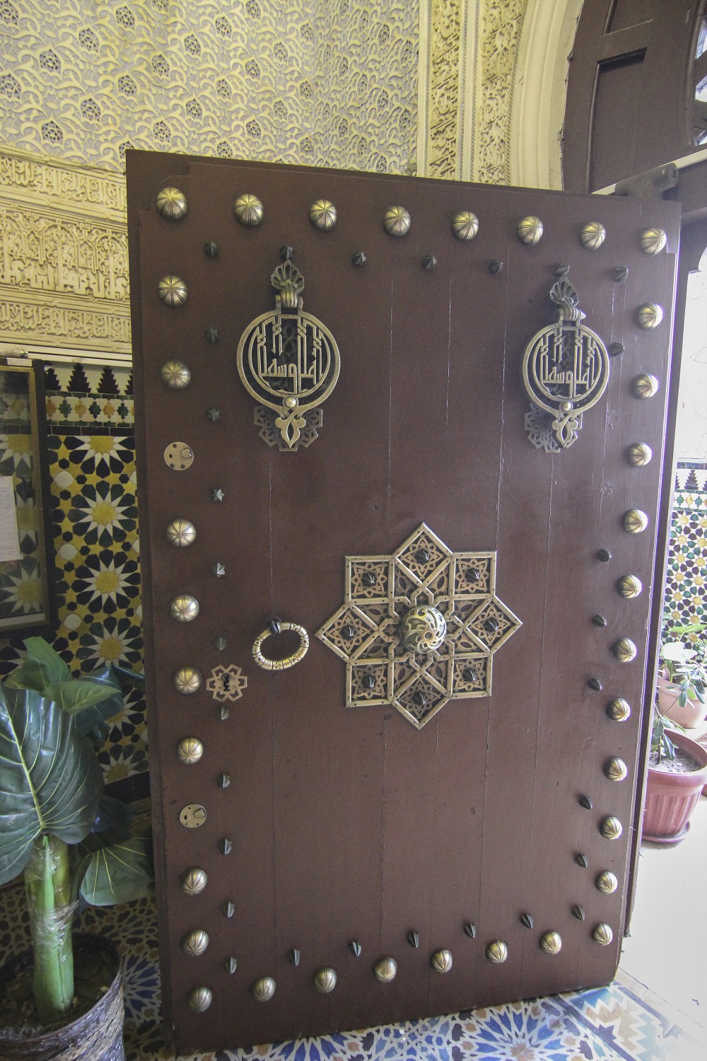 Main entrance portico, detail view of the wooden door showing carved door knocker and decorative iron nails
