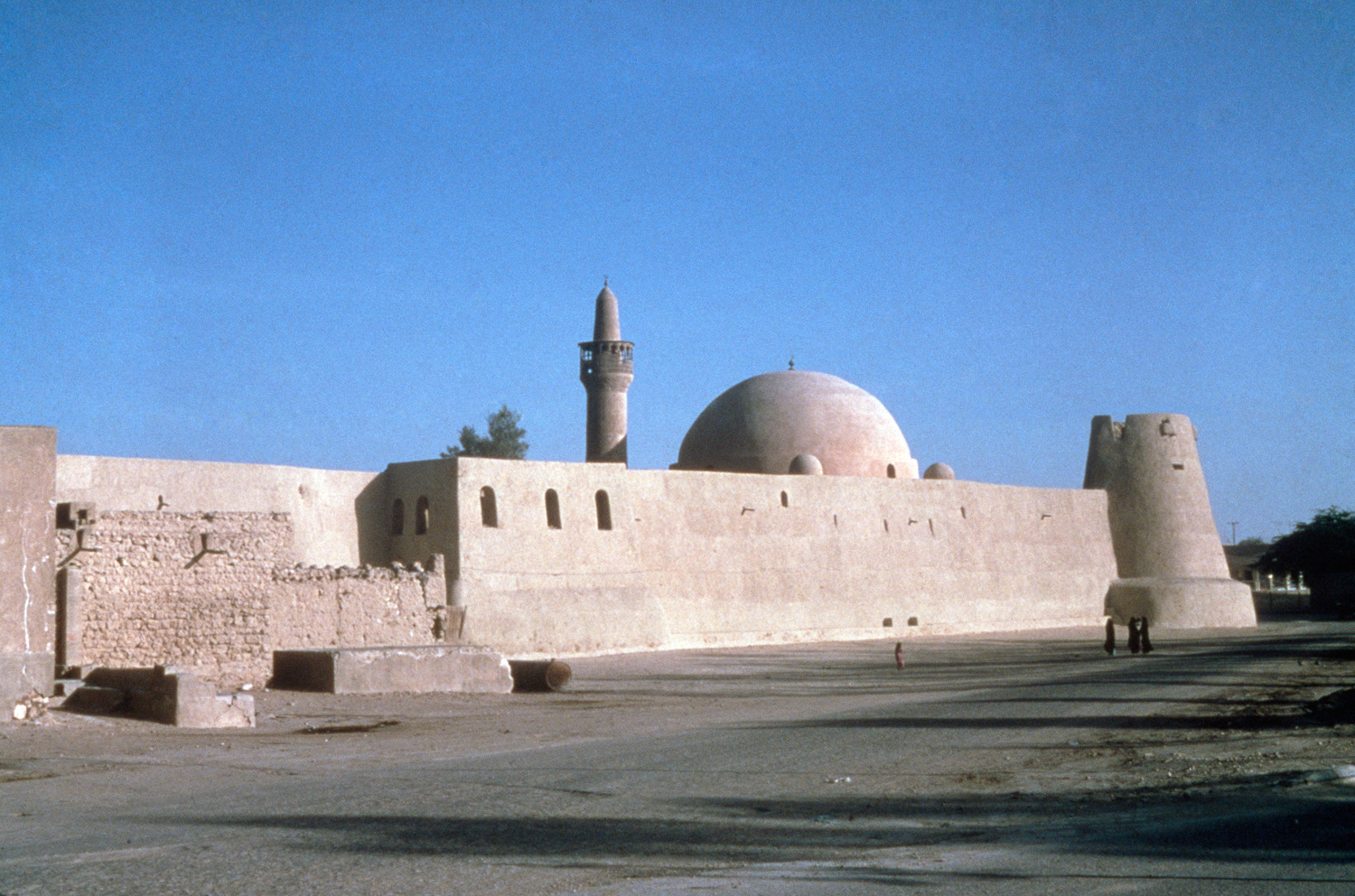 View of mosque inside fortress walls; dome and minaret visible