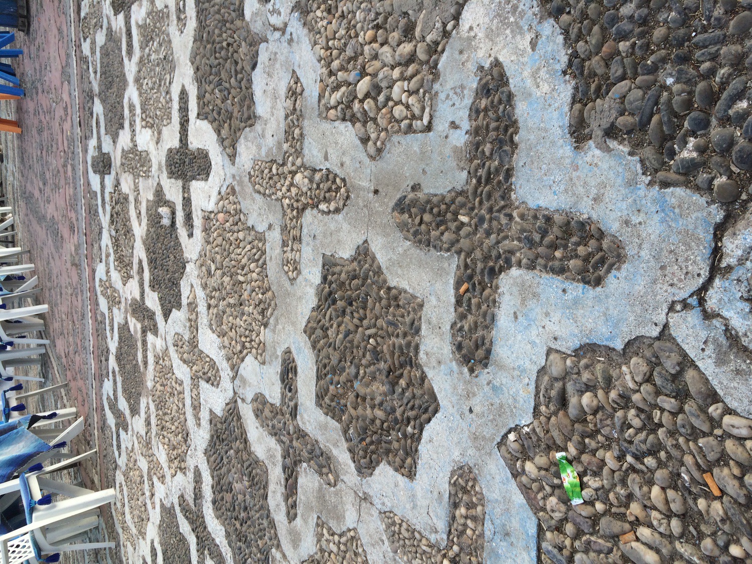 View of the 8-pointed star and cross, rough stone and mortar mosaic pattern paving the square