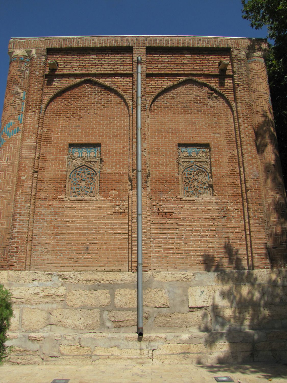 Exterior view, brick and stone back of tomb, blind arches with mosaic tile recessed panels