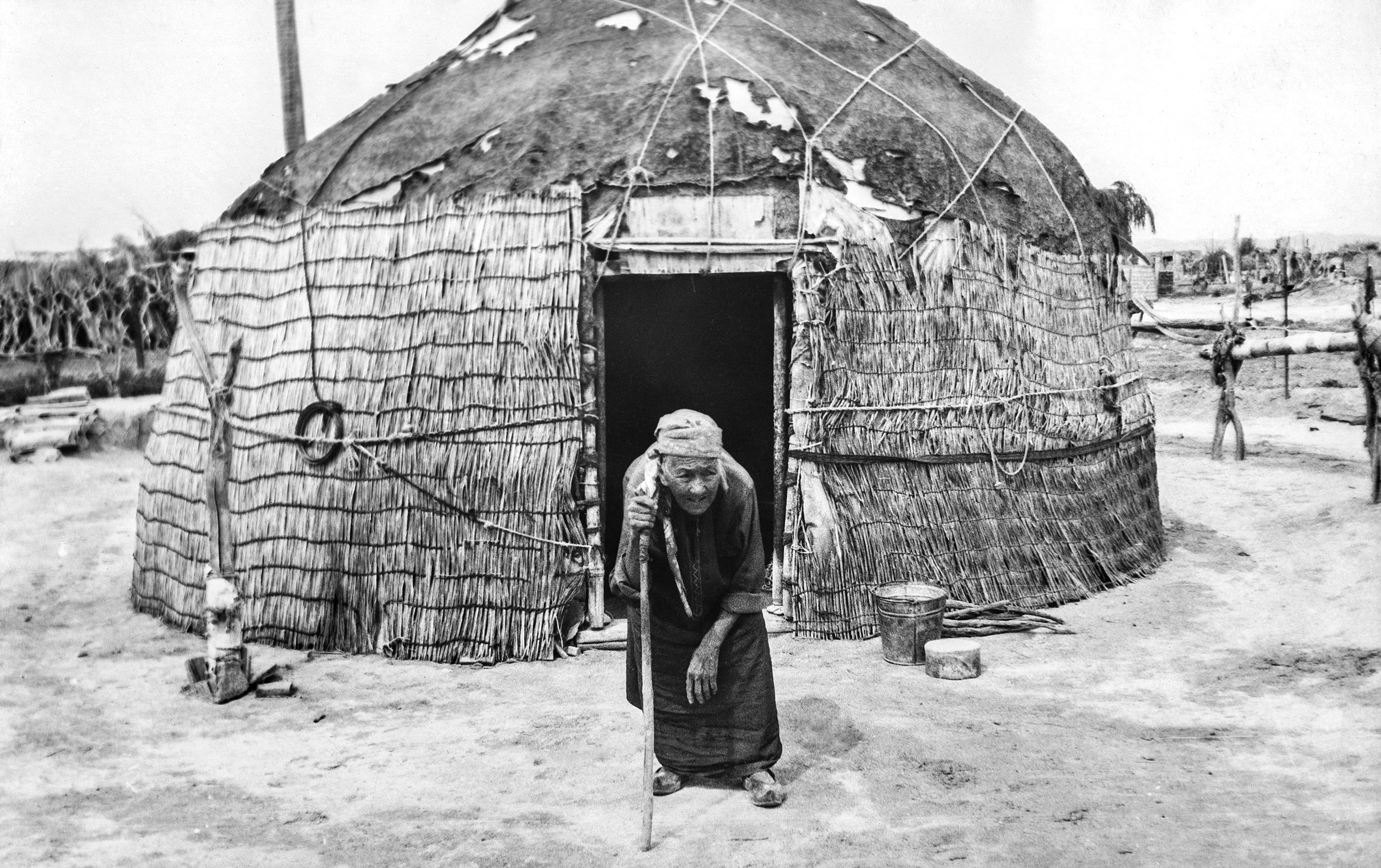 Elderly woman with walking stick seen in front of yurt (<span style="font-style: italic;">gara öy</span>).&nbsp;<p class="MsoNormal"><o:p></o:p></p>&nbsp;<br>