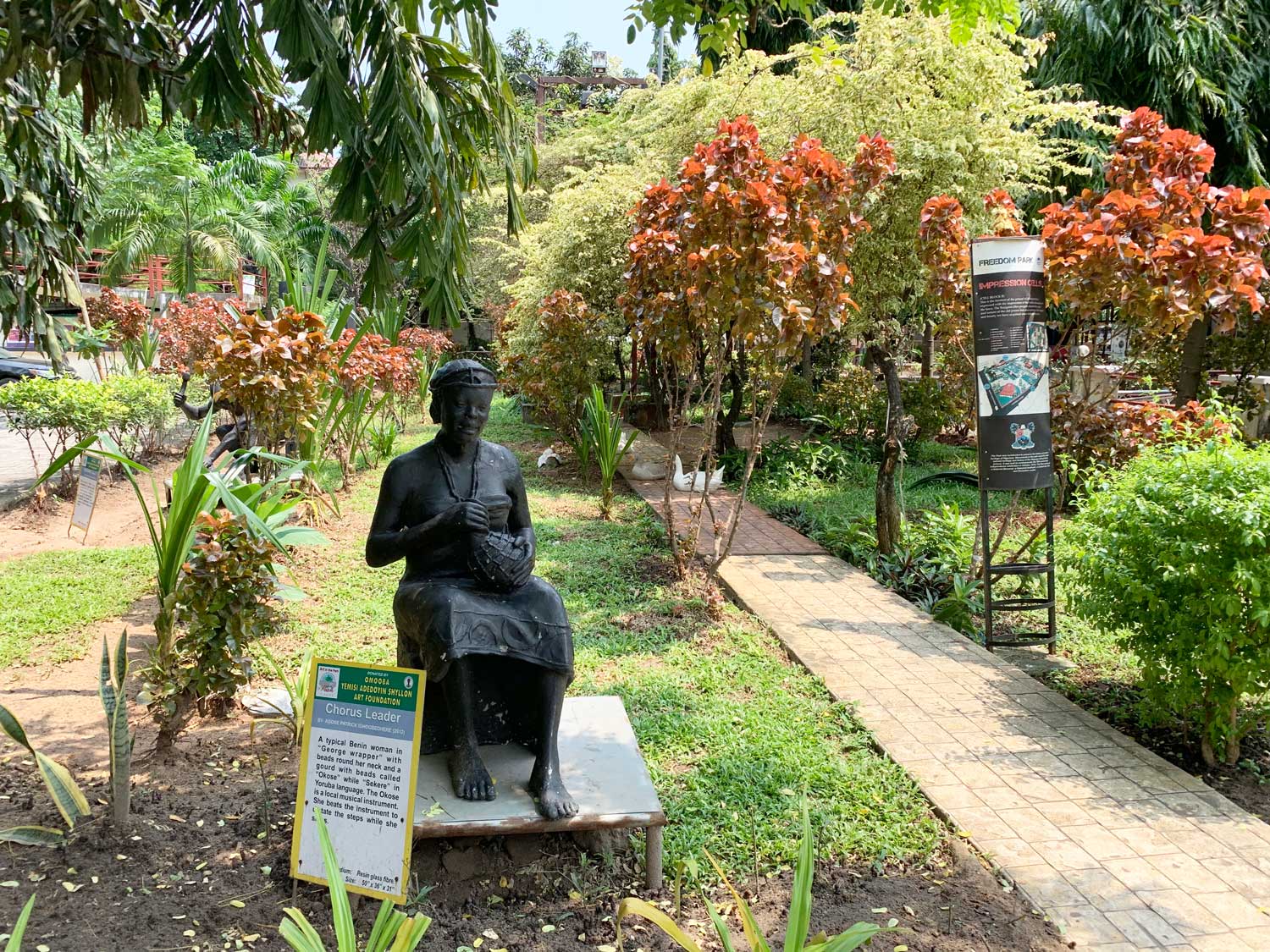 <div>Statue of a chorus leader and brick walkways through the garden</div>