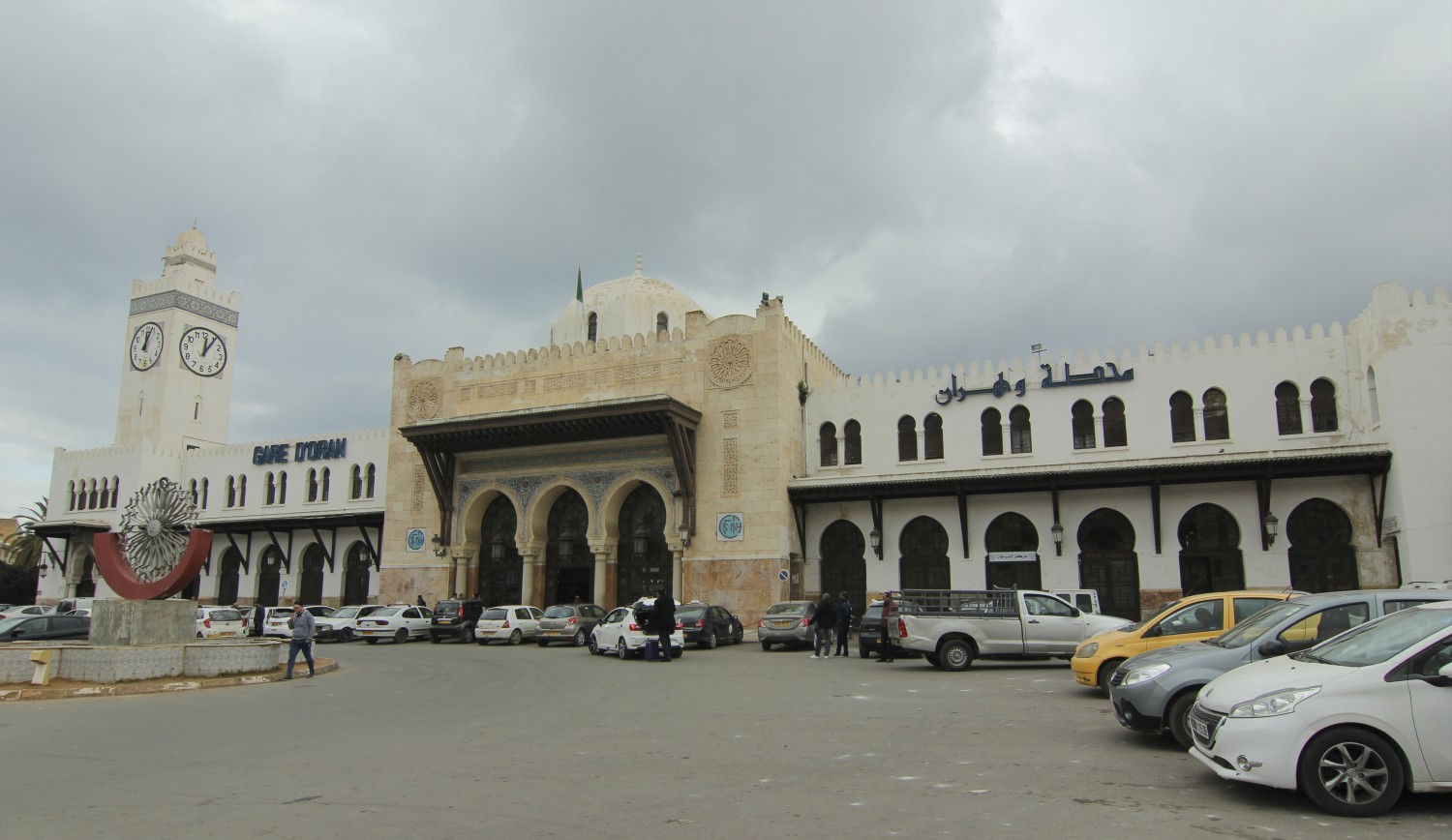 Full view of the train station showing the main entrance and minaret-style clock tower